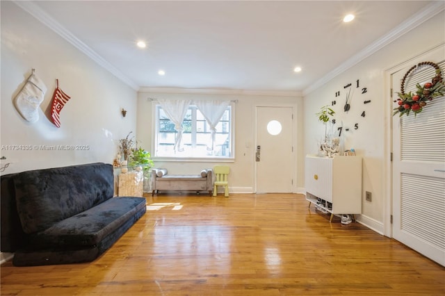 foyer with ornamental molding and light hardwood / wood-style floors