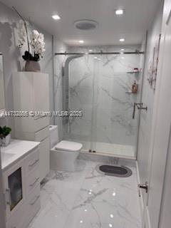 bathroom with vanity, an enclosed shower, and toilet