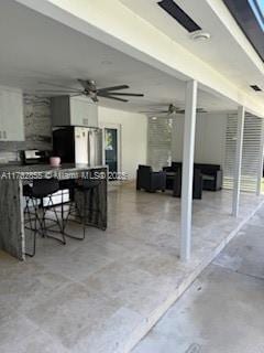 view of patio featuring ceiling fan and exterior bar