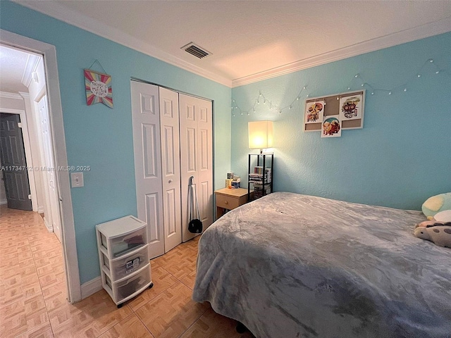 bedroom featuring light parquet floors, ornamental molding, and a closet