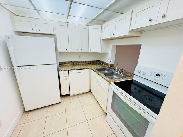 kitchen with light tile patterned flooring, sink, a paneled ceiling, white appliances, and white cabinets