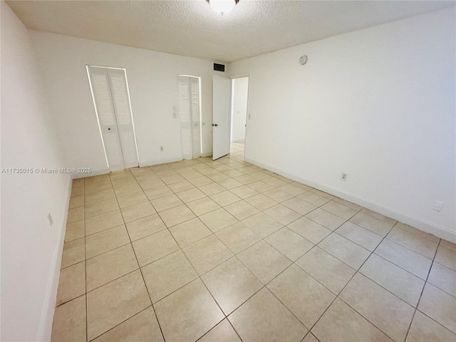 unfurnished room with a textured ceiling