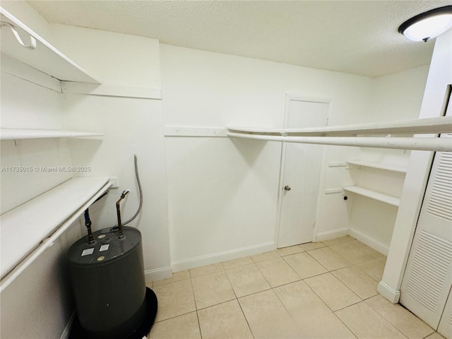 laundry area featuring light tile patterned floors and a textured ceiling