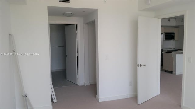 hallway featuring light carpet and track lighting