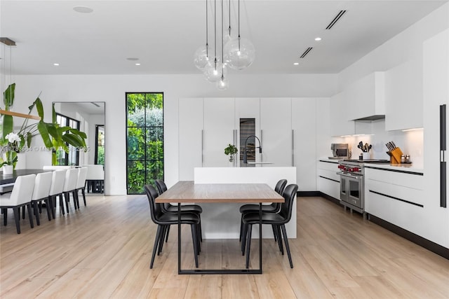 dining space with light hardwood / wood-style floors and sink