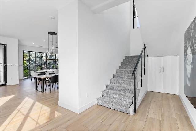 stairs featuring an inviting chandelier and hardwood / wood-style flooring