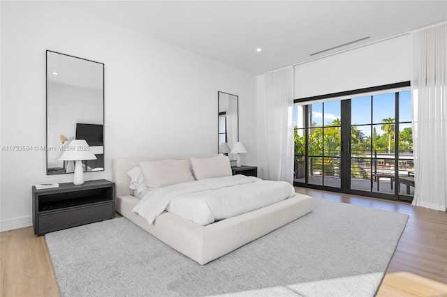 bedroom with hardwood / wood-style floors, access to outside, and french doors