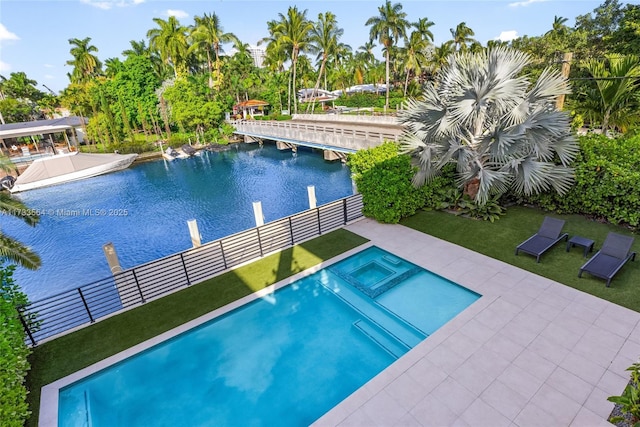 view of pool with a lawn, an in ground hot tub, and a water view