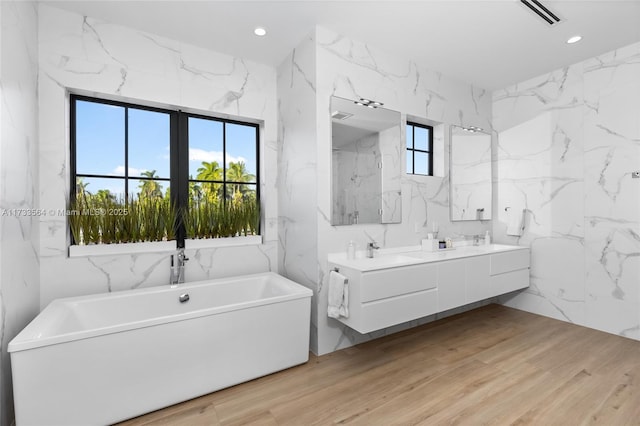 bathroom featuring vanity, a bath, and hardwood / wood-style floors