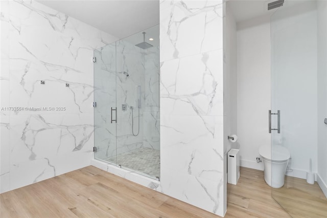 bathroom featuring hardwood / wood-style floors, an enclosed shower, and toilet