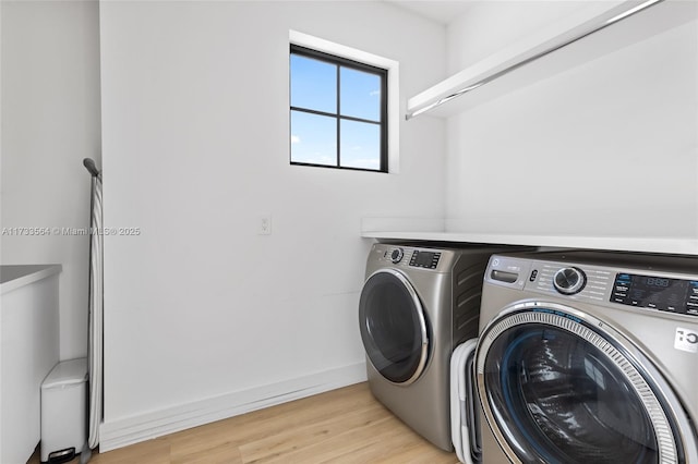 laundry area featuring washer and dryer and light wood-type flooring