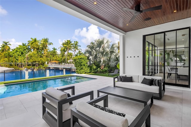 view of swimming pool with ceiling fan, an outdoor living space, and a patio