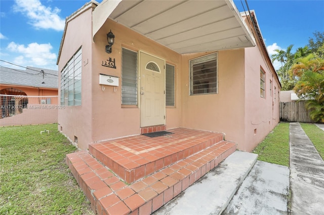 property entrance featuring a lawn