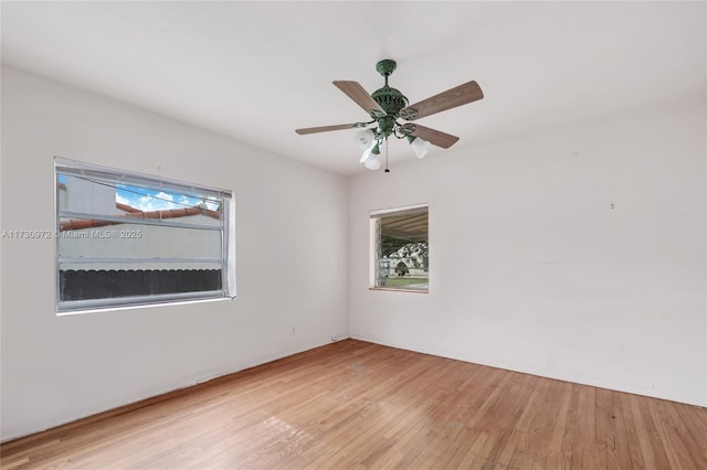 empty room with ceiling fan, light wood-type flooring, and a wealth of natural light