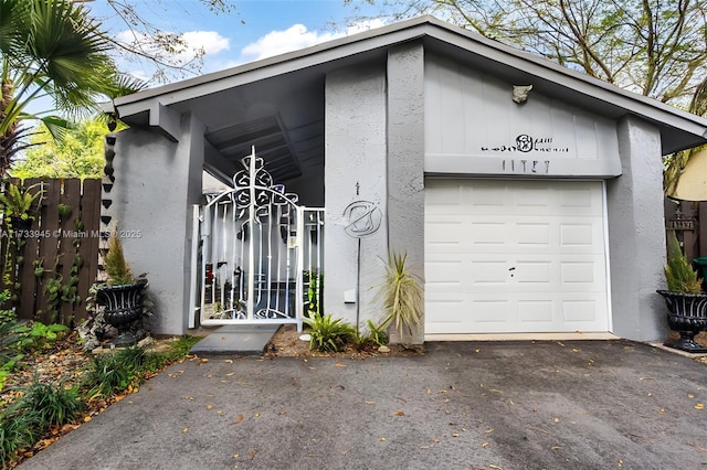 garage with a gate and driveway