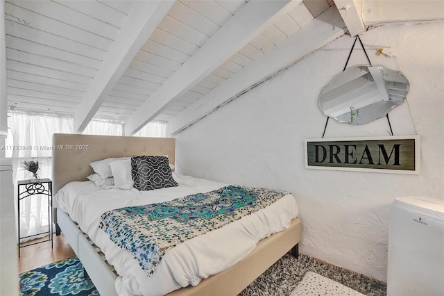 bedroom with lofted ceiling with beams, wood ceiling, wood finished floors, and a textured wall