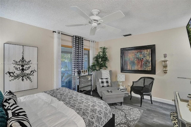 bedroom featuring dark wood-style flooring, visible vents, a textured ceiling, and baseboards