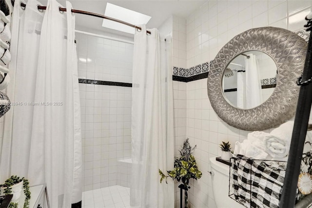 full bathroom featuring tiled shower and tile walls