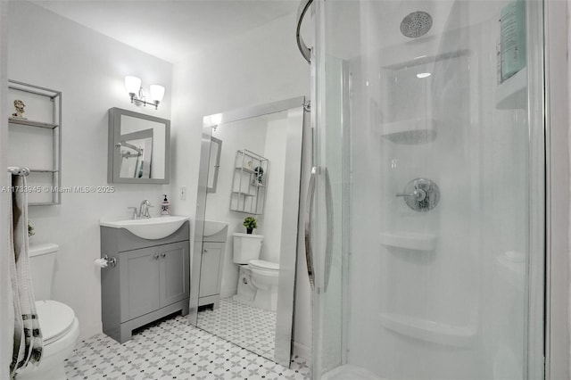 full bath featuring toilet, a shower stall, and vanity