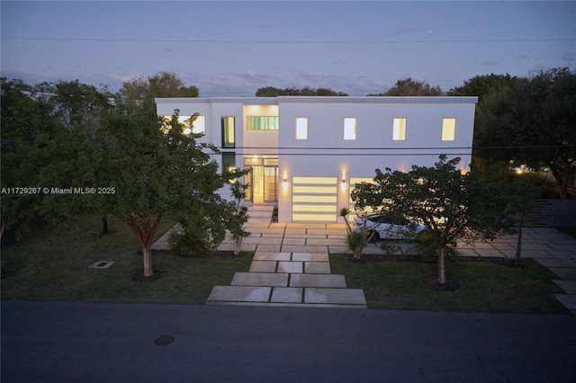 view of front of house featuring a garage and a yard