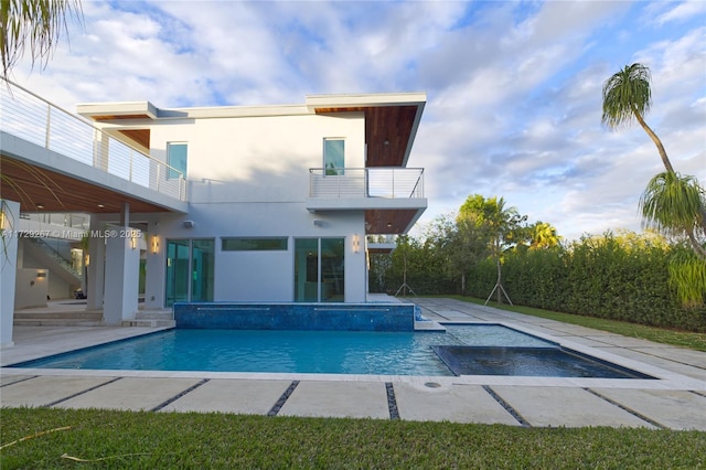 view of swimming pool with a hot tub and a patio