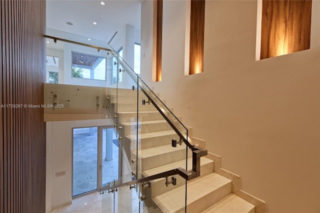 staircase featuring a towering ceiling