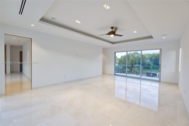 spare room featuring ceiling fan and a tray ceiling