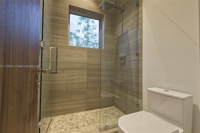 bathroom with an enclosed shower and toilet