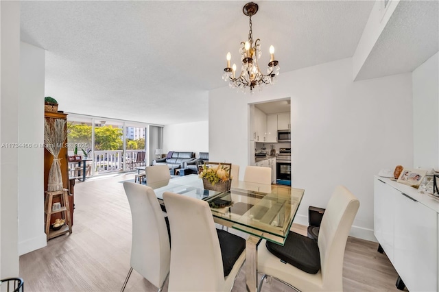 dining space with light wood-type flooring, baseboards, a textured ceiling, and expansive windows