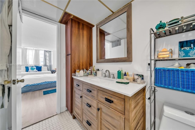 ensuite bathroom featuring tile patterned flooring, connected bathroom, and vanity