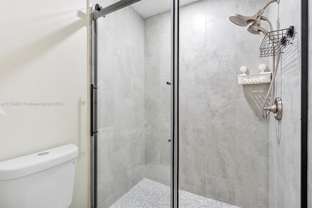 bathroom featuring an enclosed shower and toilet