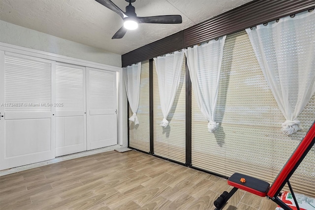 unfurnished bedroom featuring ceiling fan, light hardwood / wood-style floors, a closet, and a textured ceiling