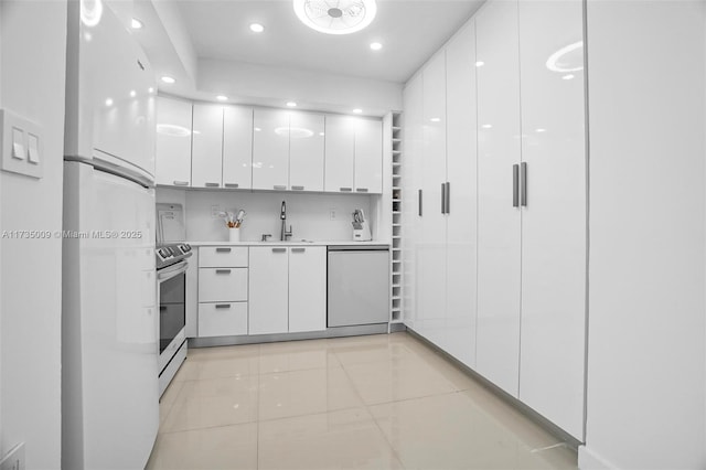 kitchen featuring sink, white refrigerator, dishwashing machine, electric stove, and white cabinets