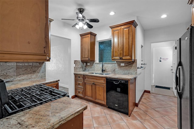 kitchen featuring light tile patterned floors, light stone countertops, sink, and black appliances