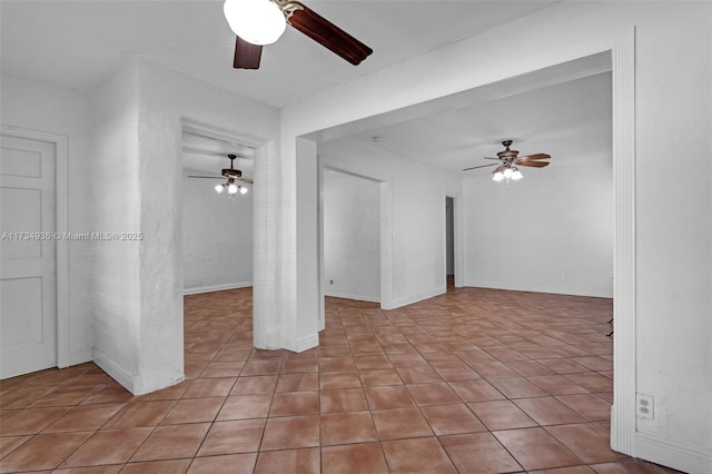 tiled spare room featuring ceiling fan