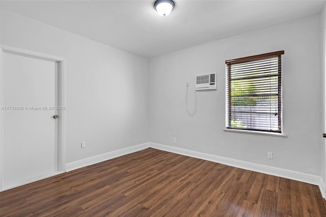 empty room with dark wood-type flooring and an AC wall unit