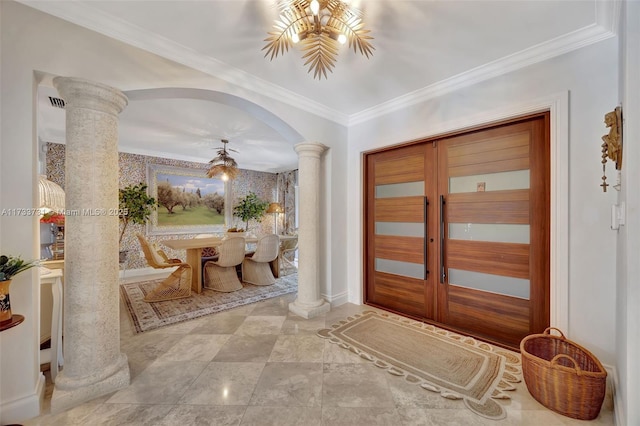 foyer with ornate columns, ornamental molding, and french doors