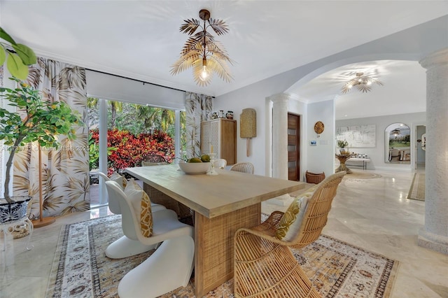 dining area with crown molding and ornate columns