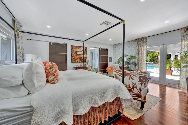 bedroom with french doors, a barn door, hardwood / wood-style floors, and access to exterior