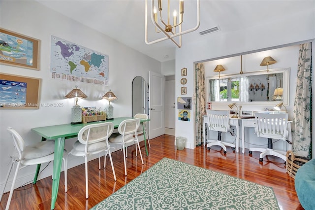 dining room with hardwood / wood-style floors and a notable chandelier