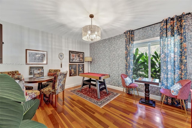 dining space featuring hardwood / wood-style floors and an inviting chandelier