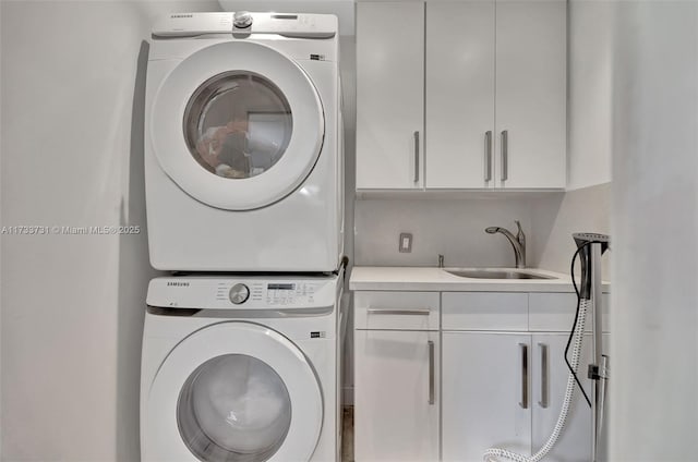 laundry area with stacked washer and dryer, sink, and cabinets