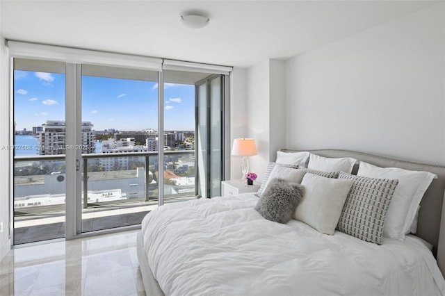 bedroom with a water view, access to outside, and a wall of windows