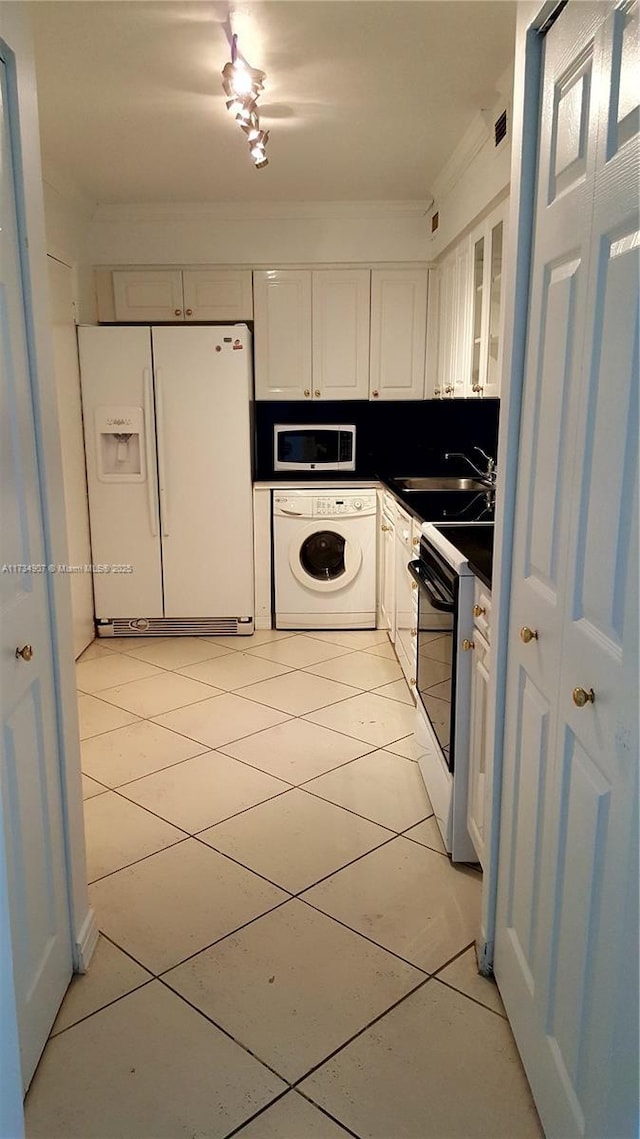 kitchen featuring electric stove, white fridge with ice dispenser, white cabinets, built in microwave, and washer / clothes dryer