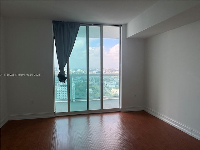 spare room with floor to ceiling windows and hardwood / wood-style floors