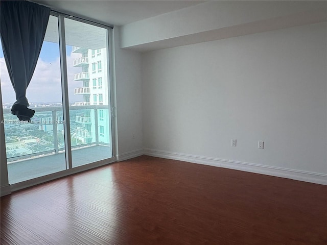 unfurnished room featuring hardwood / wood-style flooring and expansive windows