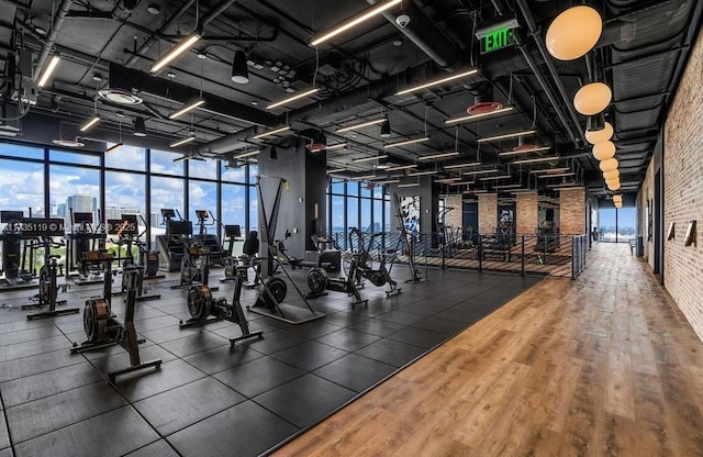 exercise room with expansive windows and brick wall