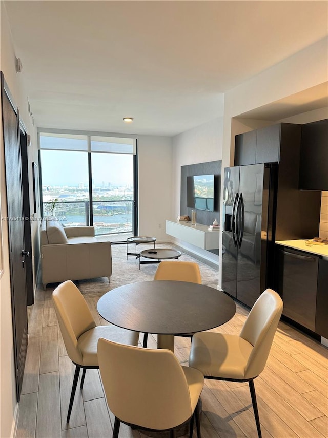 dining room featuring a wall of windows and light hardwood / wood-style floors