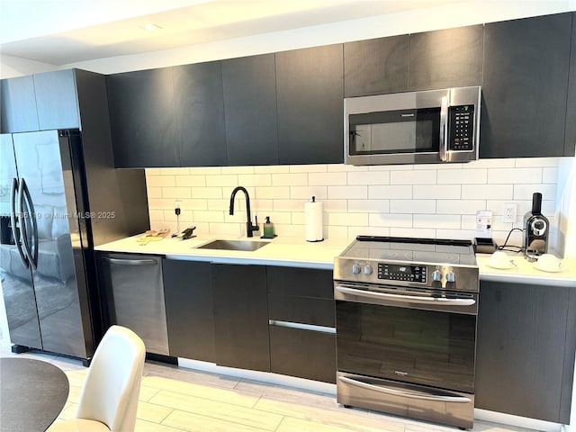 kitchen with tasteful backsplash, appliances with stainless steel finishes, and sink