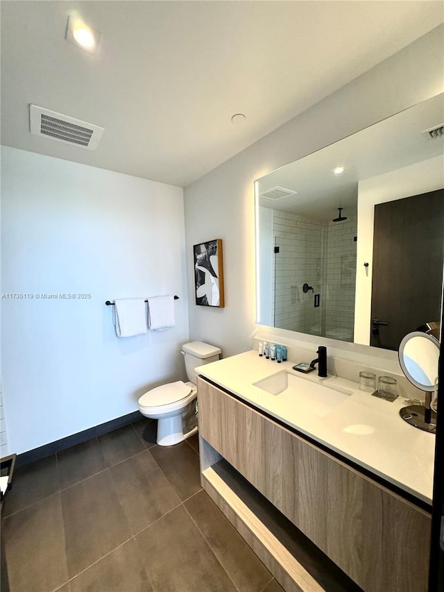 bathroom with vanity, toilet, tile patterned floors, and a shower with shower door